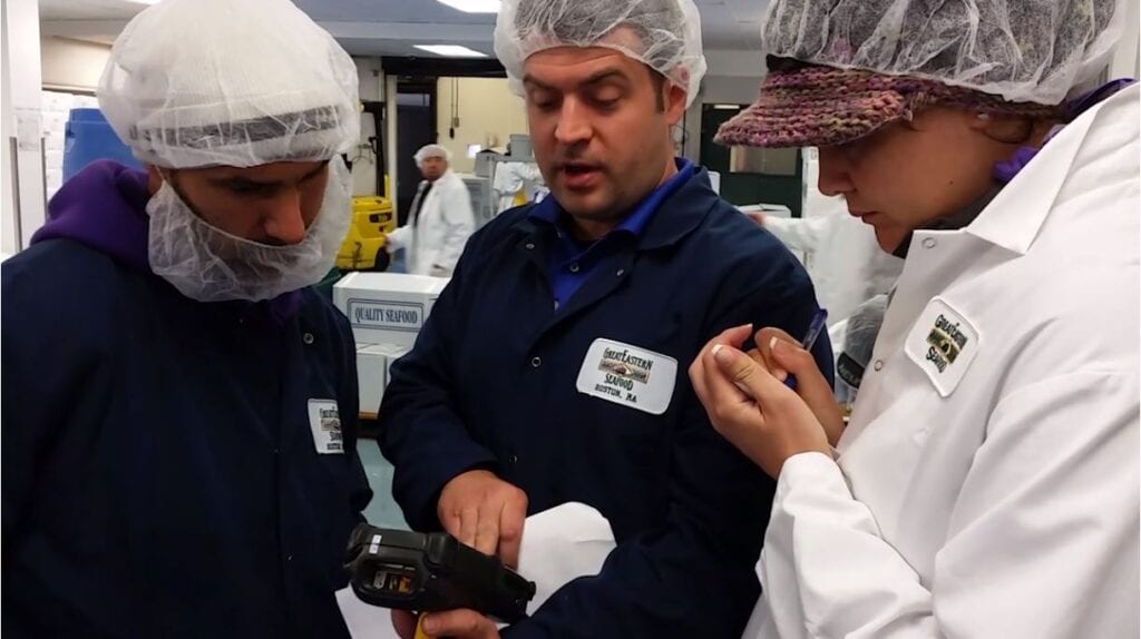 Plant workers looking at scanner screen